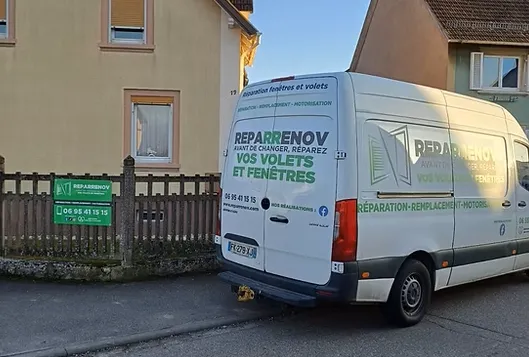 Le camion atelier Reparrenov garé devant une habitation alsacienne, avec les panneaux de la marque